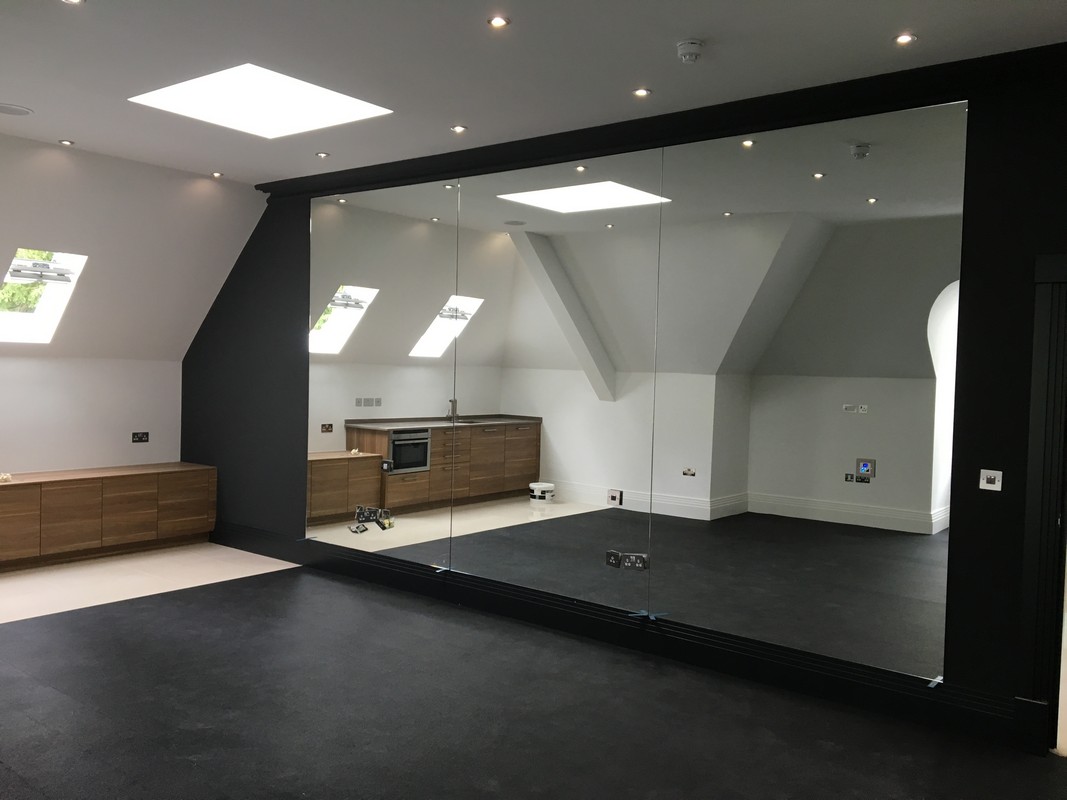 Frameless glass wall dividing loft conversion in Herne Hill